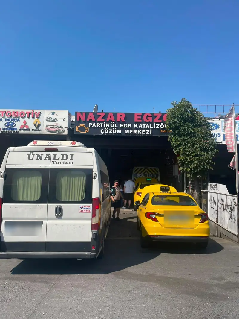 Sanayi sitesi içinden Nazar Egzoz tabelası, önde minibüs ve taksi